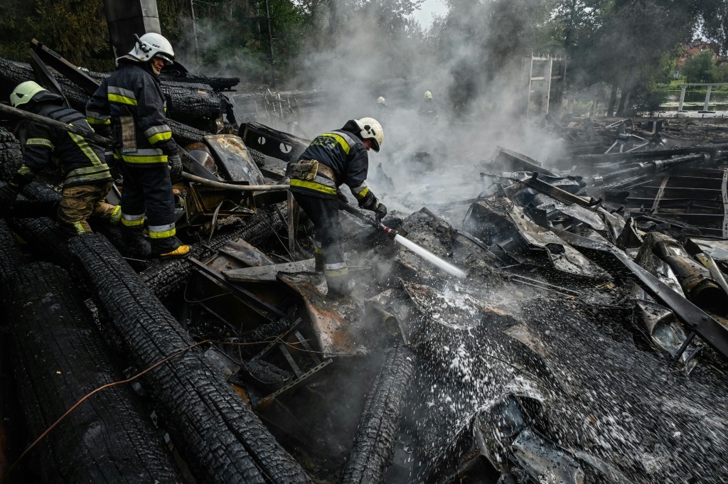 عناصر إطفاء يخمدون حريقًا في أنقاض مطعم دمّره صاروخ في خاركيف في شرق أوكرانيا في الرابع من أيلول/سبتمبر 2022 (ا ف ب)