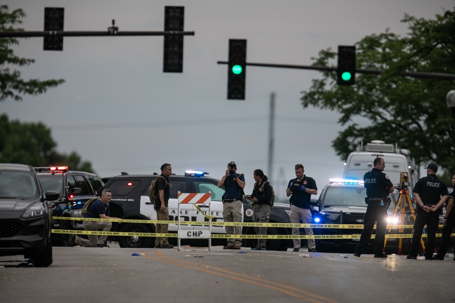 ضباط الشرطة يلتقطون صورا ويحققون في موقع شهد حادث إطلاق نار جماعي في هايلاند بارك، إلينوي، الولايات المتحدة، في 4 يوليو 2022. (شينخوا)