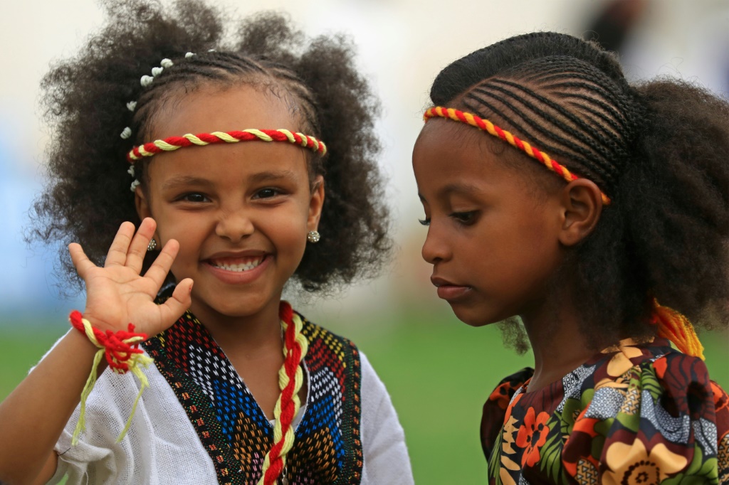 فتاتان أثيوبيتان تضعان عصابتي رأس بألوان علم تيغراي خلال احتفالات أشنده في حديقة القرشي بالعاصمة السودانية الخرطوم (اف ب)