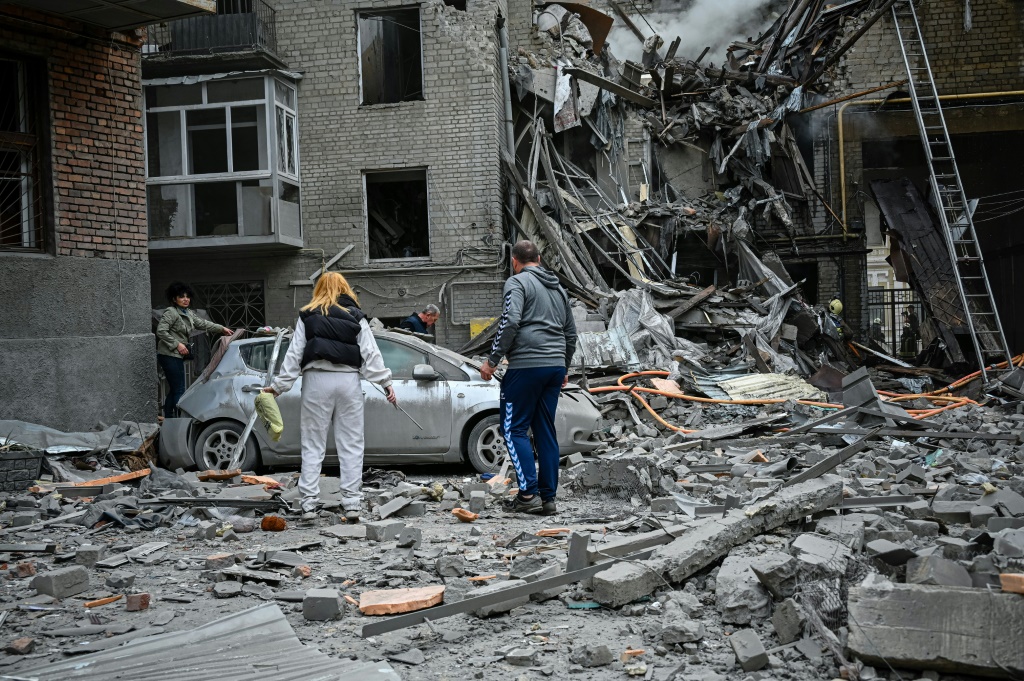 سكان وسط الأنقاض بعد إصابة شقة بضربة صاروخية في خاركيف في 6 سبتمبر 2022(ا ف ب)