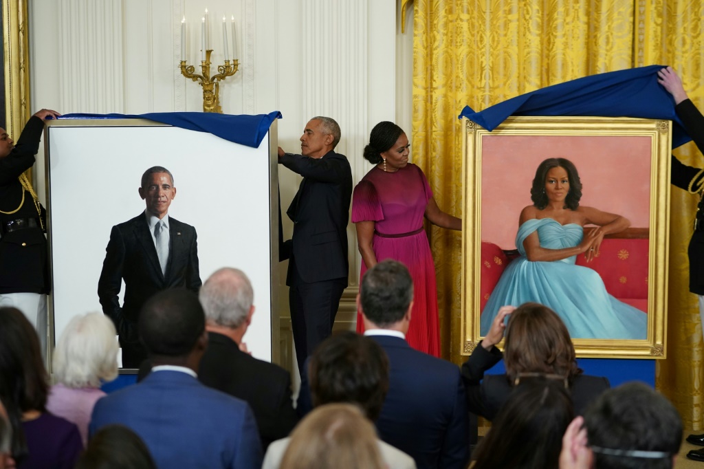 الرئيس الأميركي السابق باراك أوباما وزوجته ميشيل يرفعان الستارة في 7 أيلول/سبتمبر 2022 في البيت الأبيض في واشنطن عن اللوحتين الرسميتين اللتين تمثلانهما (ا ف ب)