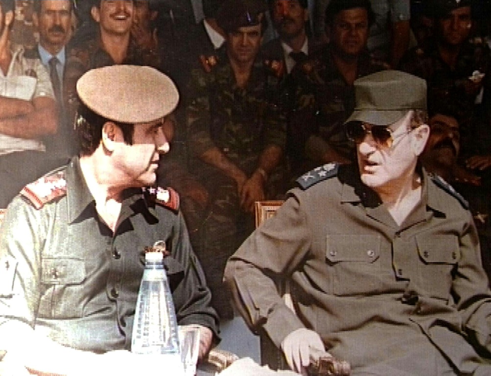 صورة من الأرشيف ملتقطة في الأول من كانون الثاني/يناير 1984 تظهر الرئيس السوري الراحل حافظ الأسد (يمين) إلى جانب شقيقه الأصغر رفعت الأسد (يسار)خلال مراسم عسكرية في دمشق (أ ف ب)