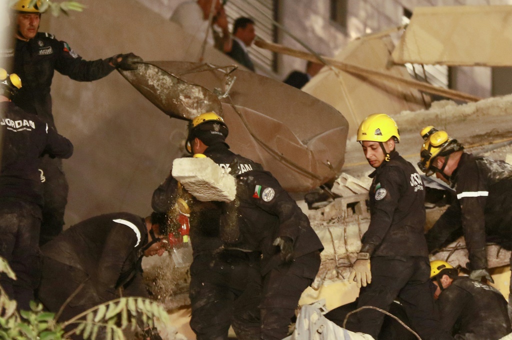 عمال الانقاذ يبحثون عن مفقودين تحت انقاض مبنى سكني مؤلف من أربعة طوابق انهار في وسط عمان في 13 أيلول/سبتمبر 2022 (ا ف ب)