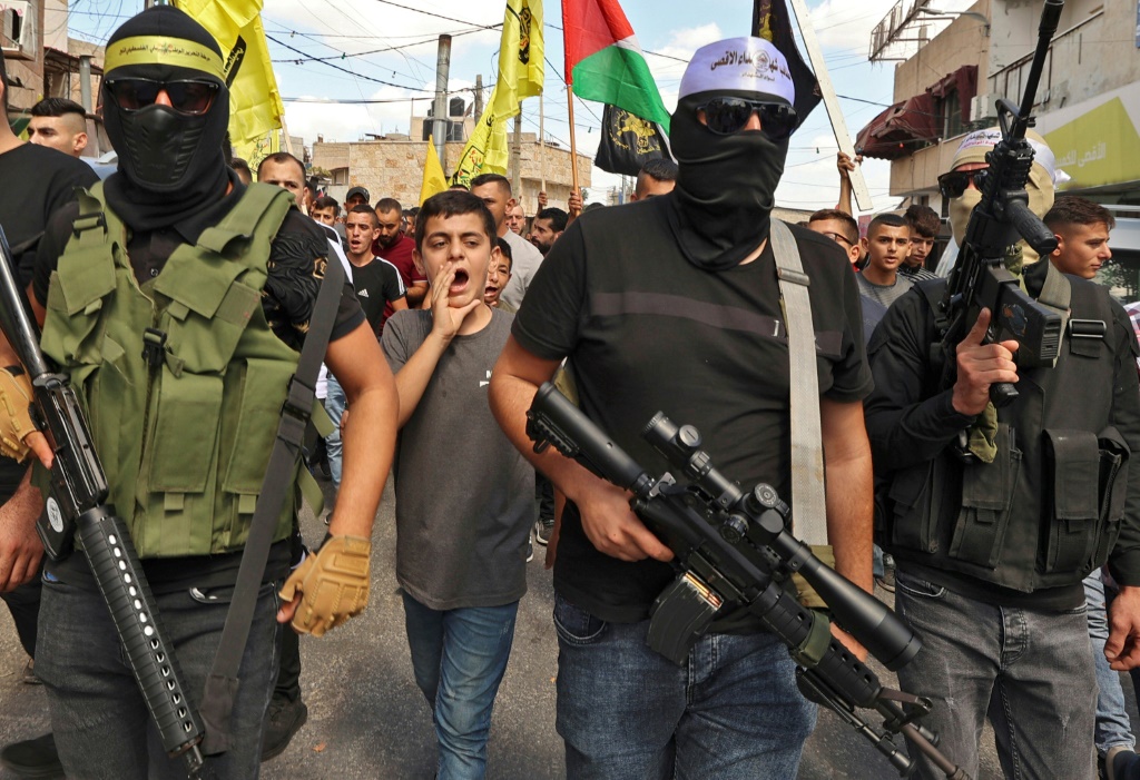 مواطنون ومسلحون فلسطينيون يخرجون في مسيرة لمؤازرة عائلتي شابين فلسطينيين قتلا برصاص الجيش الاسرائيلي في تبادل لإطلاق النار قرب معبر الجلمة شمال الضفة الغربية في 14 أيلول/سبتمبر 2022 كما قتل ضابط إسرائيلي في العملية (أ ف ب)