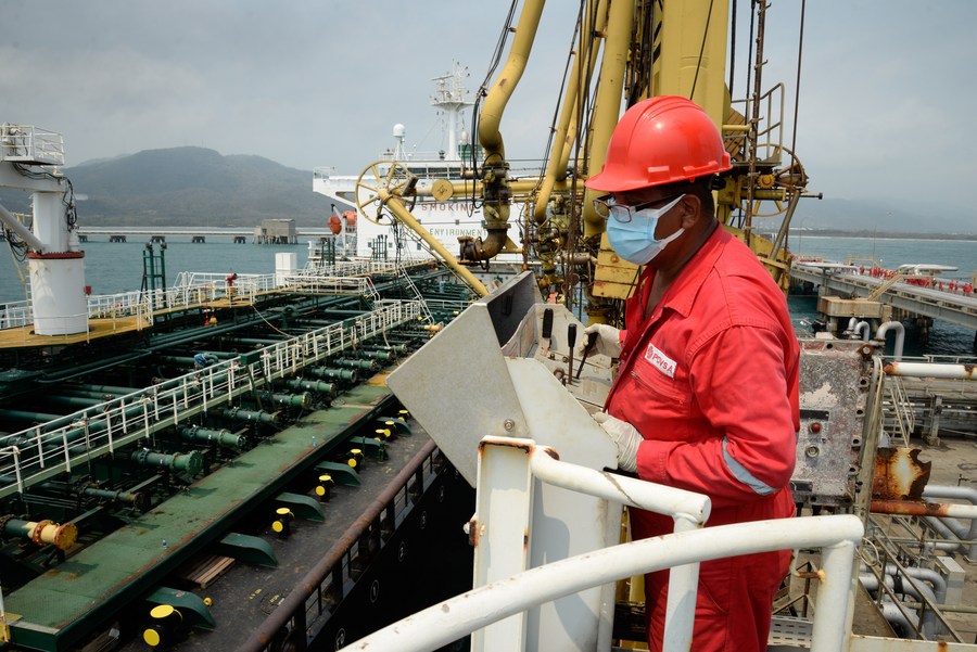 عامل في شركة النفط الوطنية الفنزويلية يقوم بتشغيل آلة أمام ناقلة النفط " فورتشن"، ترسى على مصفاة البليتو بولاية كارابوبو في فنزويلا يوم 25 مايو 2020. (شينخوا)