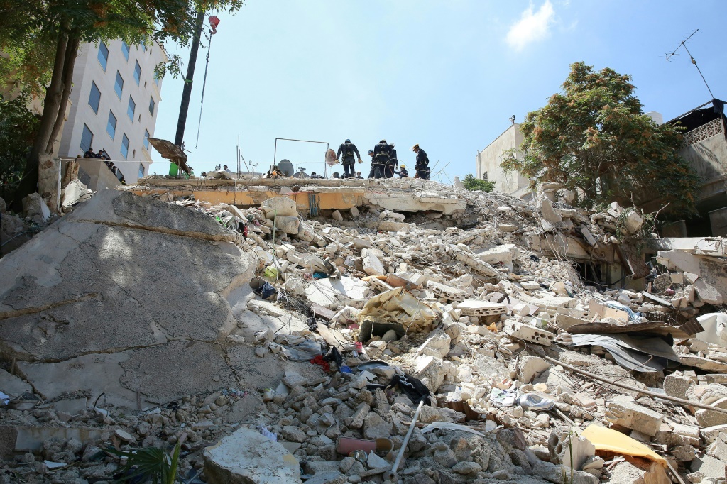 عمال إنقاذ بين انقاض مبنى منهار في عمان في 14 أيلول/سبتمبر 2022 (ا ف ب )