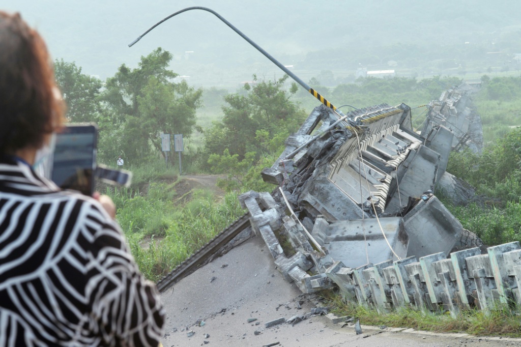 مواطنة تايوانية تصور جسر كوالياو في منطقة هوالين في شرق الجزيرة في 19 أيلول/سبتمبر 2022 غداة زلزال بقوة 6,9 درجات تسبب بانهياره (ا ف ب)