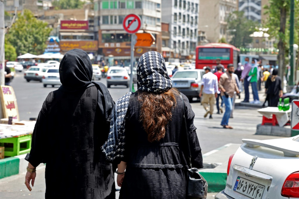 امرأتان في أحد شوارع العاصمة الإيرانية طهران قرب ساحة تجريش في 12 تموز/يوليو 2022 (ا ف ب)