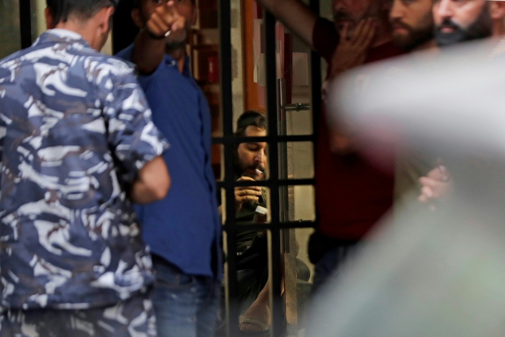 اللبناني بسام الشيخ حسين يدخن سيجارة قبل تسليم نفسه لقوى الأمن، داخل فدرال بنك في بيروت في 11 آب/أغسطس 2022 (اا ف ب)