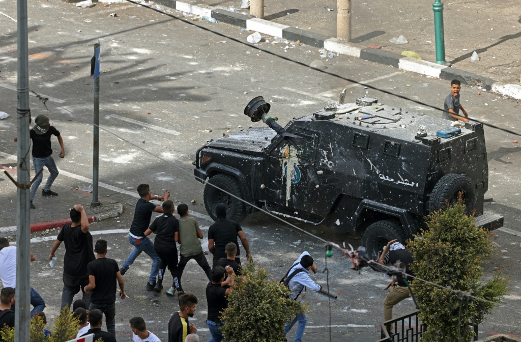  متظاهرون يلقون الحجارة على قوات الأمن الفلسطينية أثناء تنفيذها عملية اعتقال في مدينة نابلس الرئيسية في شمال الضفة الغربية (ا ف ب)