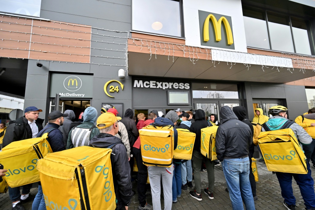 عمال التوصيل يجتمعون في مطعم ماكدونالد لاستلام الطلبات في كييف (اف ب)