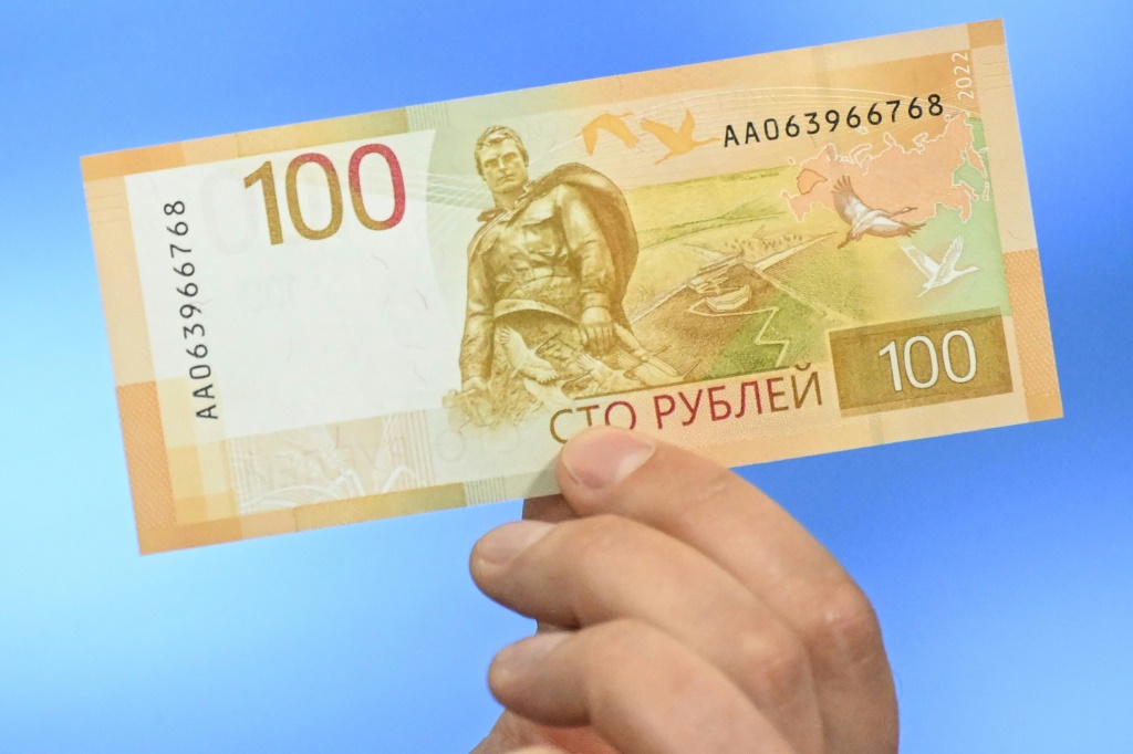 موظف في البنك المركزي الروسي يعرض نسخة معدلة من فئة المئة روبل خلال عرضها رسميا في موسكو في 30 حزيران/يونيو 2022 (ا ف ب).