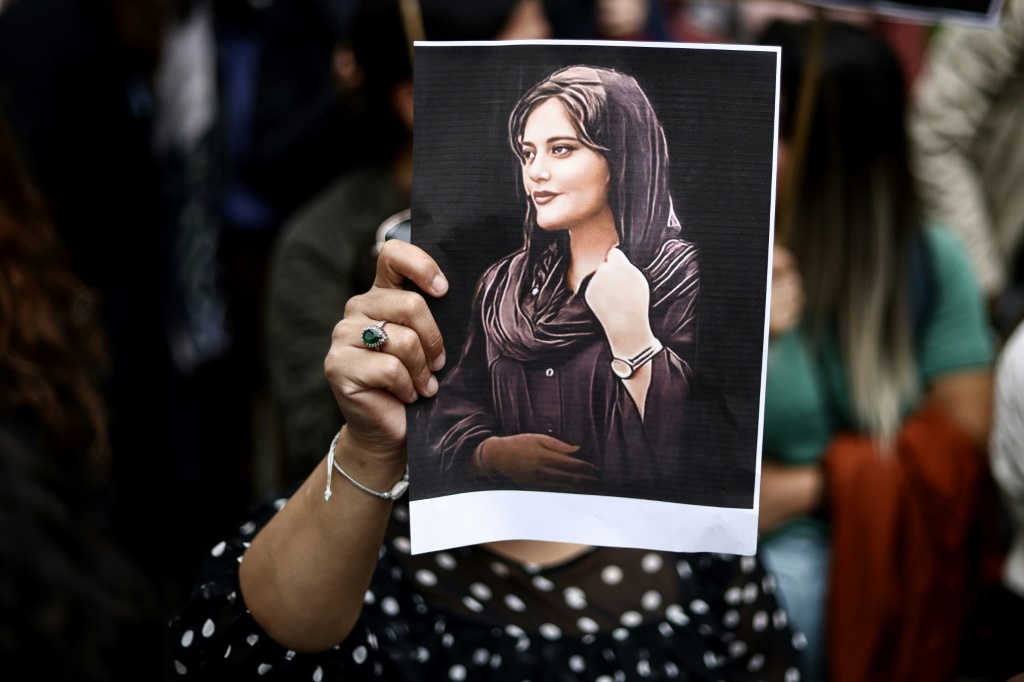 متظاهرة ترفع صورة لمهسا أميني خلال تجمع أمام السفارة الإيرانية في بروكسل في 23 أيلول/سبتبمر 2022استنكارا لوفاتها بعدما أوقفتها شرطة الأخلاق في طهران (أ ف ب)
