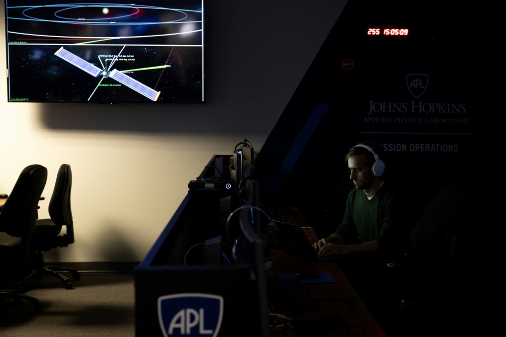 رجل يجلس في محطة عمله داخل مركز عمليات البعثة لسفينة الفضاء المزدوجة لاختبار إعادة توجيه الكويكب (DART) ، والتي تقترب بسرعة من هدفها (ا ف ب)