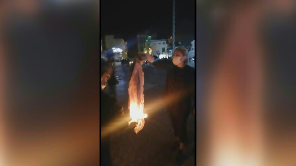    محتجون يهتفون بينما تحرق امرأة حجابها في مدينة بوشهر جنوب غرب إيران. هزت المظاهرات المدن الكبرى في جميع أنحاء إيران لمدة 10 ليالٍ متتالية ، منذ وفاة الشابة الكردية محساء أميني في حجز شرطة الأخلاق. (أ ف ب)   
