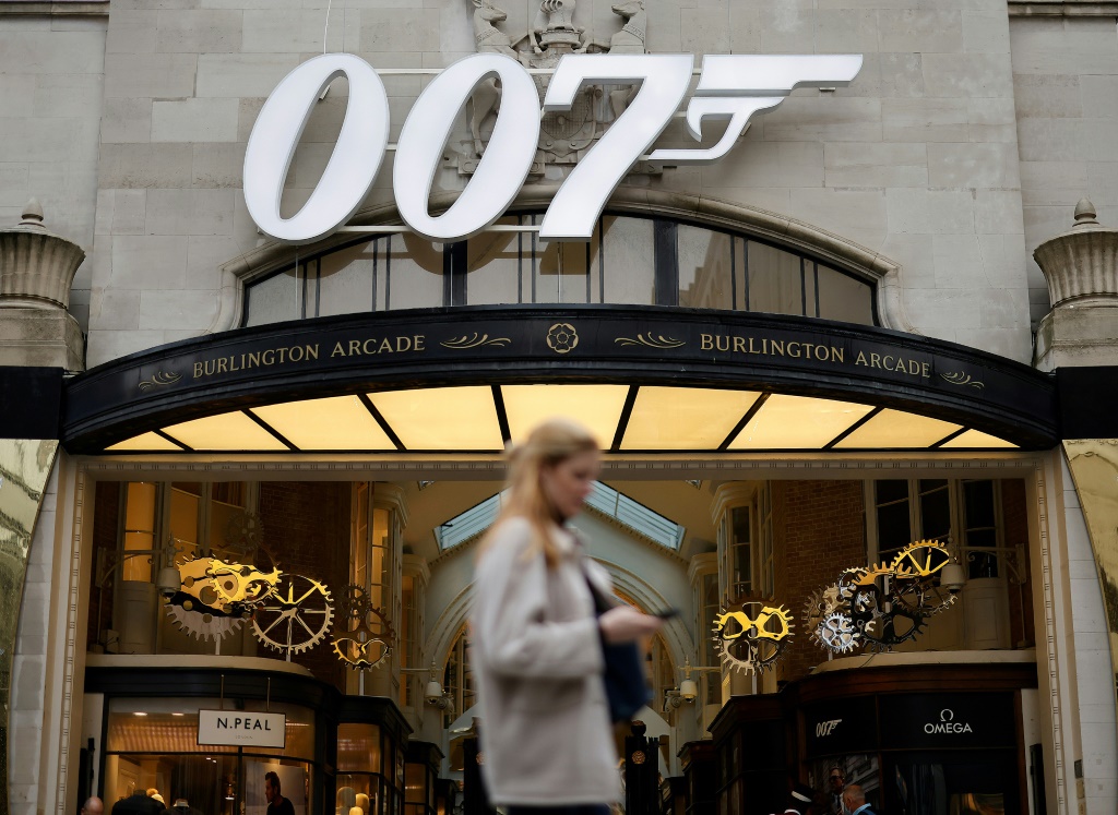 امرأة تسير أمام شعار 007 لأفلام جيمس بوتد في لندن في الرابع من تشرين الأول/أكتوبر 2021 (ا ف ب)