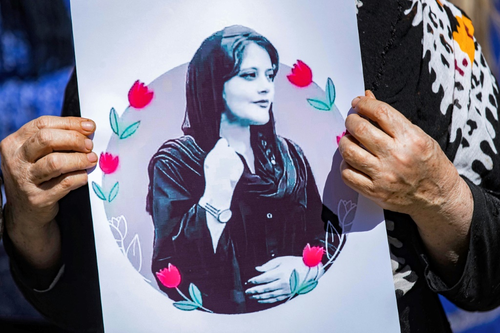امرأة تحمل صورة مهسا أميني خلال تظاهرة في الحسكة شمال شرق سوريا، في 25 أيلول/سبتمبر 2022 (ا ف ب)