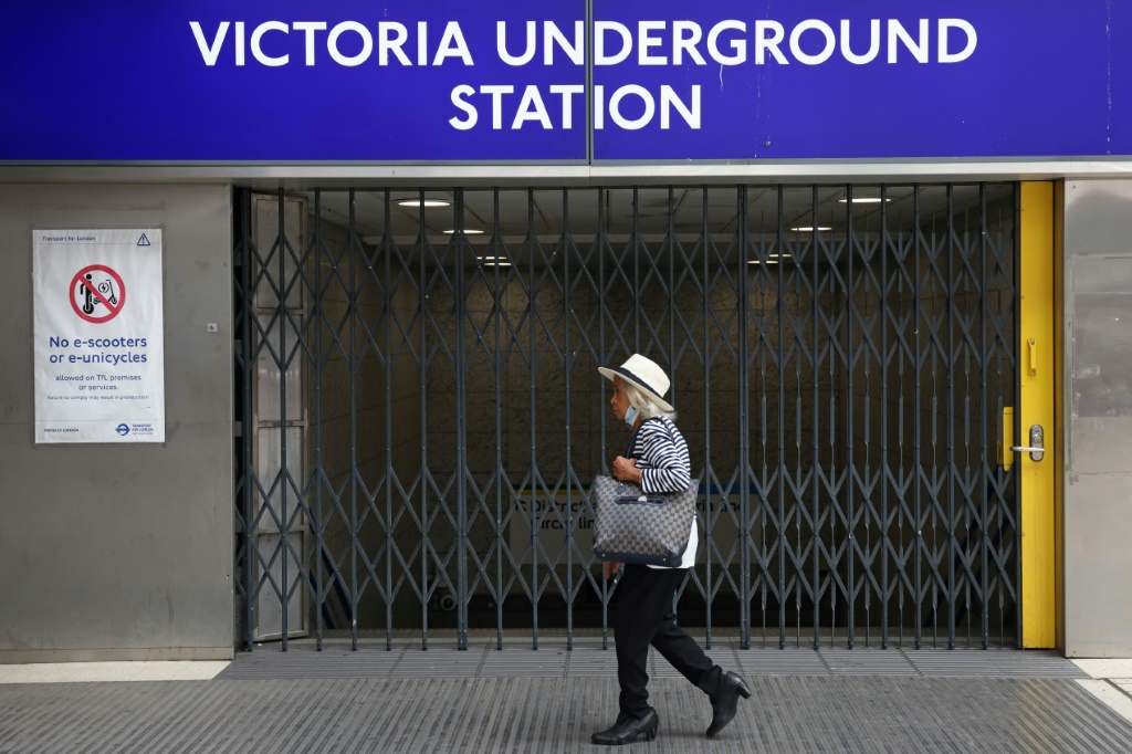 امرأة تمر من أمام محطة مغلقة للمترو في لندن بتاريخ 19 آب/اغسطس 2022 (ا ف ب)