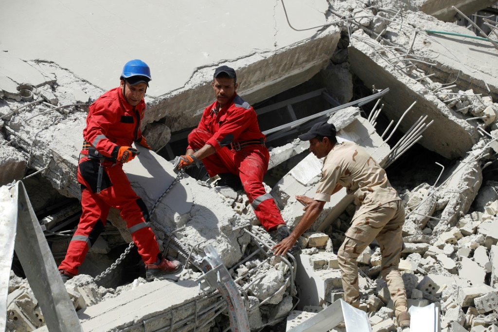 عناصر الدفاع المدني العراقي أثناء إنقاذ عالقين تحت ركام انهيار مبنى في بغداد في 1 تشرين الأول/أكتوبر 2022 (ا ف ب)
