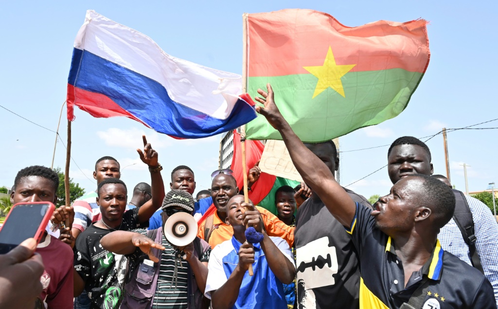 مجموعة صغيرة من المتظاهرين تحمل أعلام روسيا وبوركينا فاسو احتجاجًا على زيارة وفد للمجموعة الاقتصادية لدول غرب افريقيا في واغادوغو في 4 تشرين الأول/أكتوبر 2022 (ا ف ب)