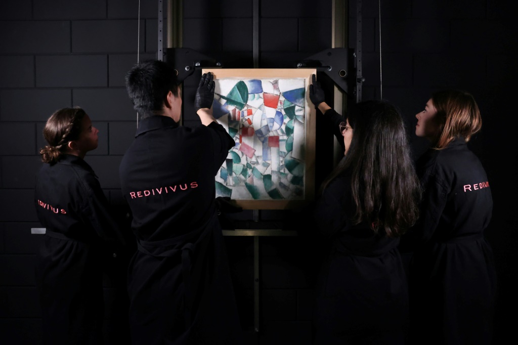 خبراء في الترميم يحملون العمل المكتشف للرسام الفرنسي فرنان ليجيه في لاهاي في الرابع من تشرين الاول/أكتوبر 2022 (ا ف ب)