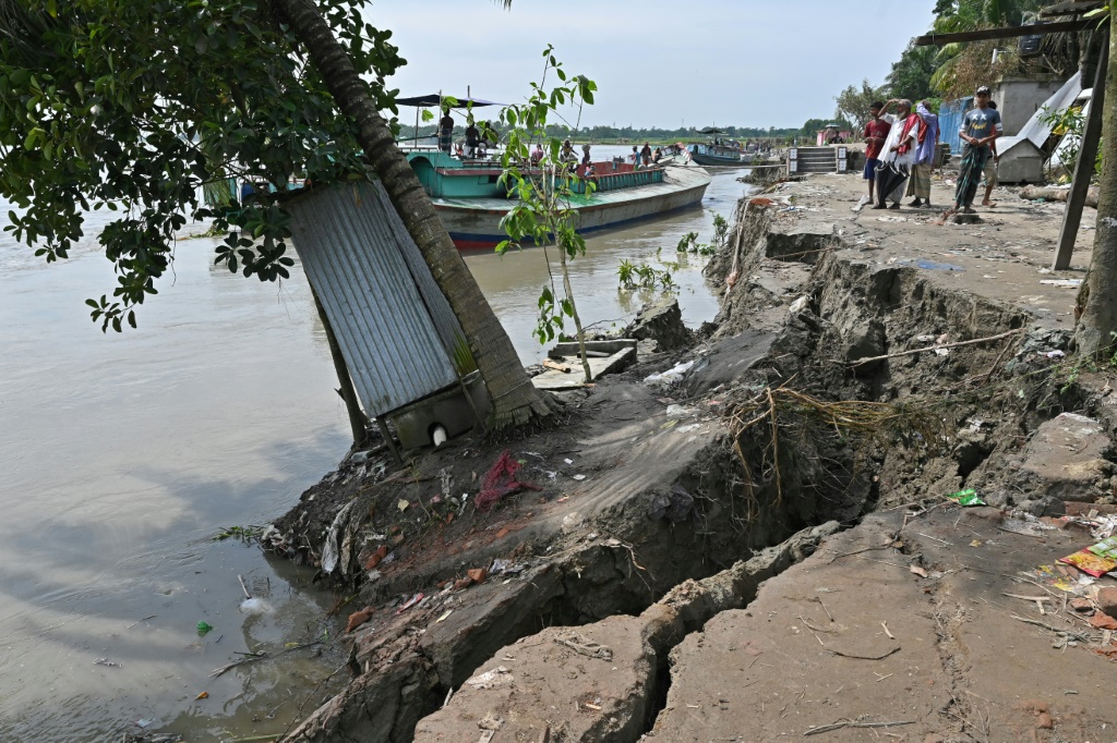 بنغلادشيون يقفون قرب جزء متآكل من نهر بادما في موشيغانج في 18 أيلول/سبتمبر 2022 (أ ف ب)