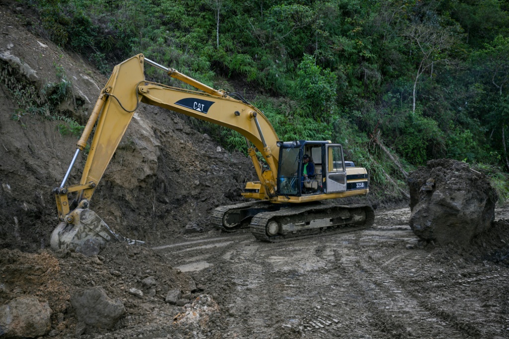 جرافة تعمل على فتح الطريق المؤدي إلى منطقة بويرتو كروز في فنزويلا إثر تكدس الطين من جراء هطول أمطار غزيرة، في 11 آب/أغسطس 2022 (ا ف ب).