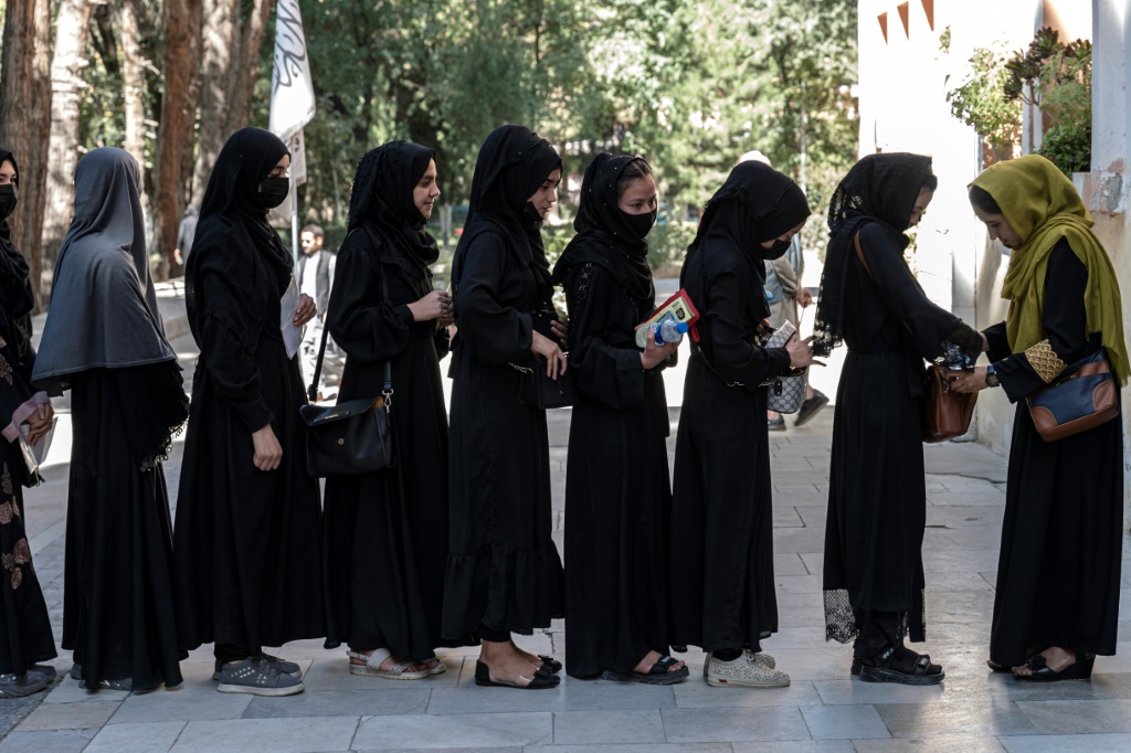  يرتدون الحجاب الأسود وحجاب الرأس ، ويقف الطلاب في طابور لامتحانات القبول خارج جامعة كابول (أ ف ب)