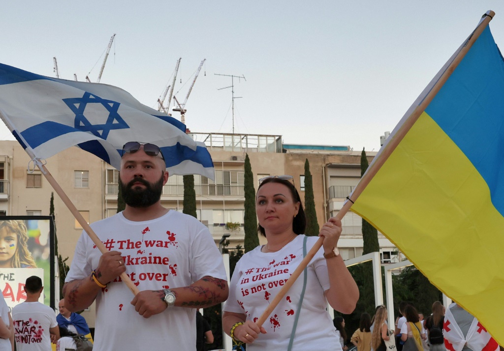 أشخاص يلوحون بالأعلام الإسرائيلية والأوكرانية في تل أبيب خلال تجمع لإحياء ذكرى استقلال أوكرانيا عن الاتحاد السوفياتي بتاريخ 24 آب/اغسطس 2022 (ا ف ب)