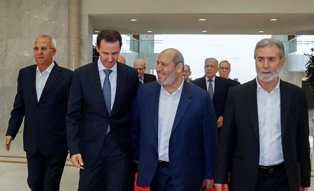 الرئيس السوري بشار الأسد مع قادة الفصائل الفلسطينية (أ ف ب)