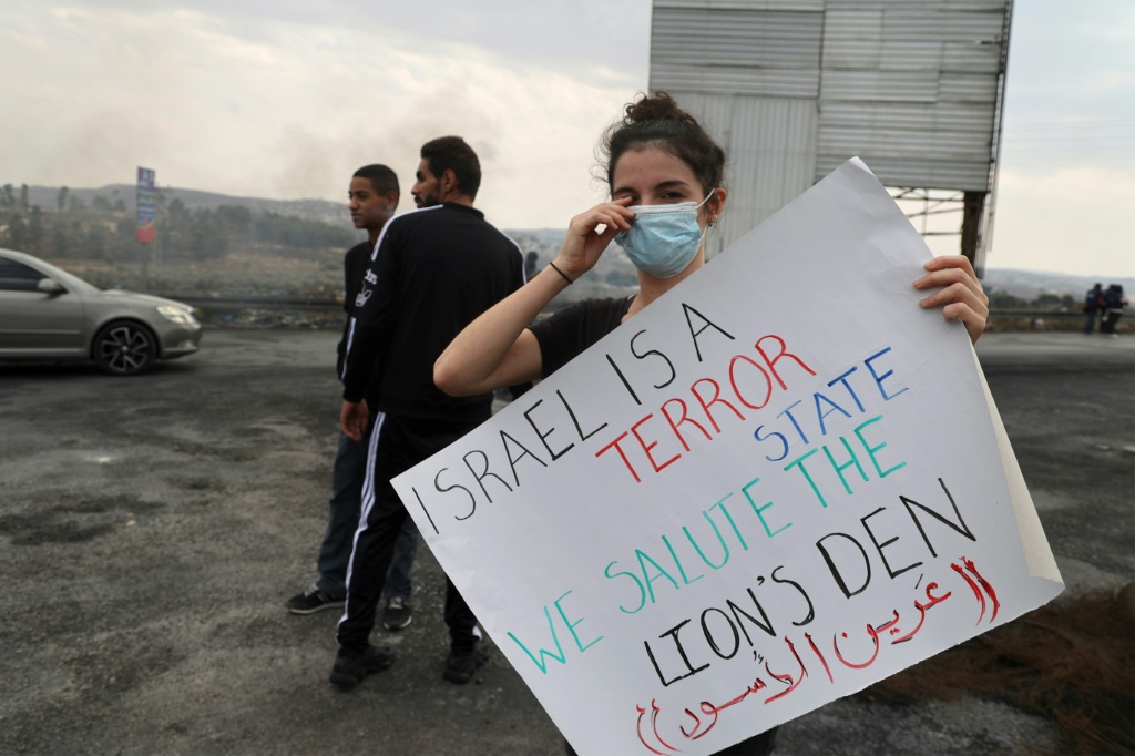 متظاهرة فلسطينية تطالب بإعادة فتح طرق حول مدينة نابلس بالضفة الغربية المحتلة في 22 تشرين الأول/أكتوبر 2022 (أ ف ب)
