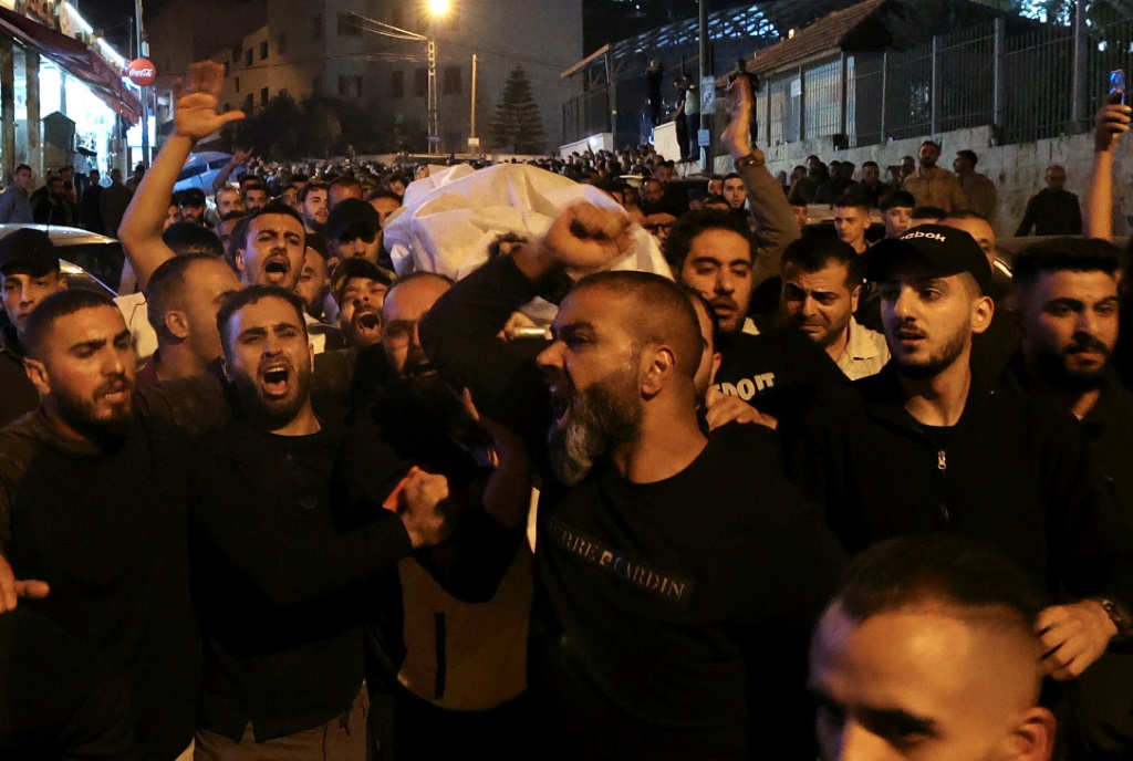 رجال يحملون جثة حمدي شرف الذي قُتل خلال العملية الإسرائيلية ليل الاثنين الثلاثاء في نابلس في الضفة الغربية في 25 تشرين الأول/أكتوبر 2022 (ا ف ب)