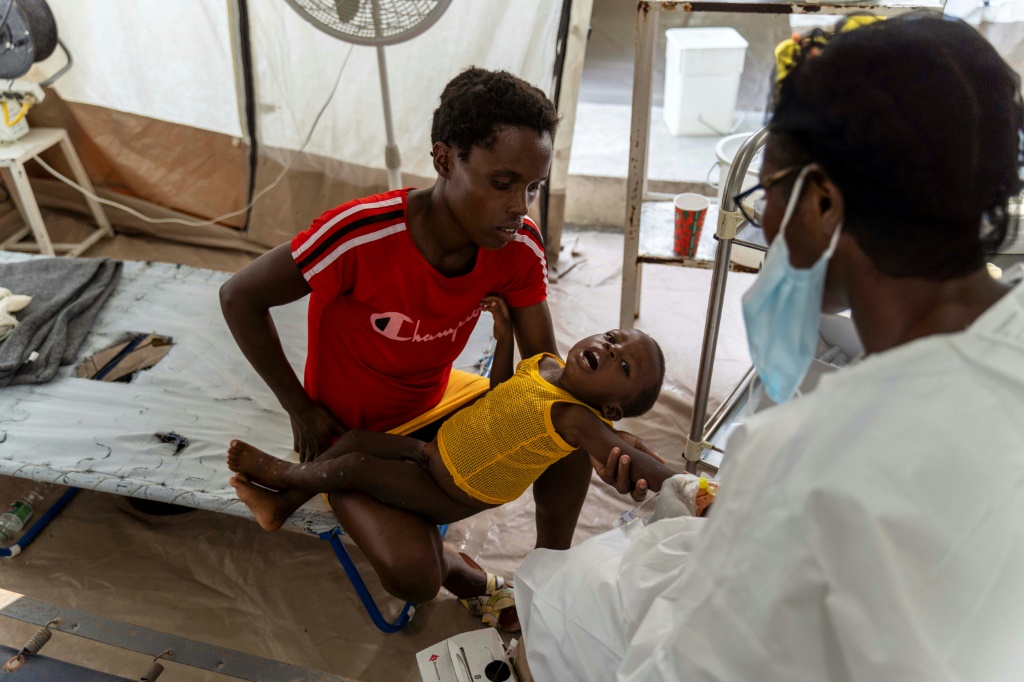 صورة من ارشيف 7 تشرين الأول/أكتوبر 2022 لامرأة تحمل طفلا يعاني من أعراض الكوليرا، في عيادة تديرها منظمة أطباء بلا حدود في سيتيه سوليه بالعاصمة الهايتية (ا ف ب)