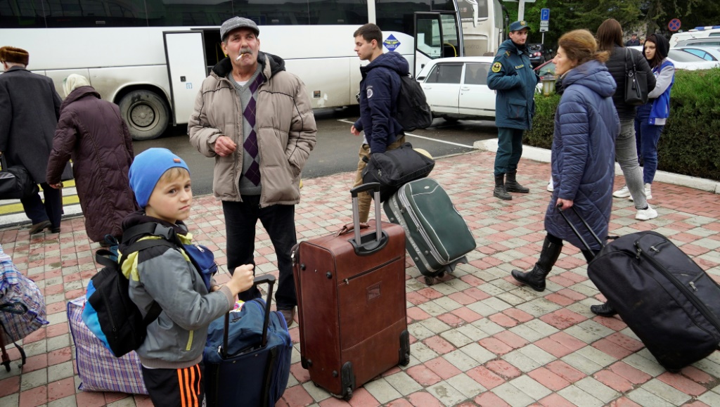 مدنيون تمّ إجلاؤهم من مدينة خيرسون يتجمّعون في محطة سكة حديد في بلدة دجانكوي في القرم لإجلائهم إلى داخل روسيا في 26 تشرين الأول/أكتوبر 2022 (ا ف ب)