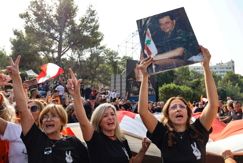    أنصار الرئيس اللبناني المنتهية ولايته ميشال عون يرفعون صورته ويرفعون العلم الوطني الكبير أمام القصر الجمهوري. (ا ف ب)