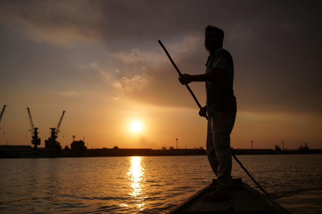 غروب الشمس على نهر دجلة: الصياد العراقي نعيم حداد يجوب شط العرب بالقرب من البصرة (ا ف ب)