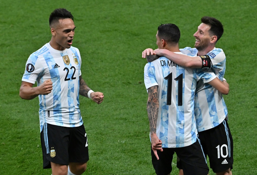 لاعبو منتخب الأرجنتين أنخل دي ماريا (في الوسط) يحتفل مع ليونيل ميسي ولاوتارو مارتينيس خلال الفوز على إيطاليا ودياً في لندن في حزيران/يونيو 2022 (ا ف ب)