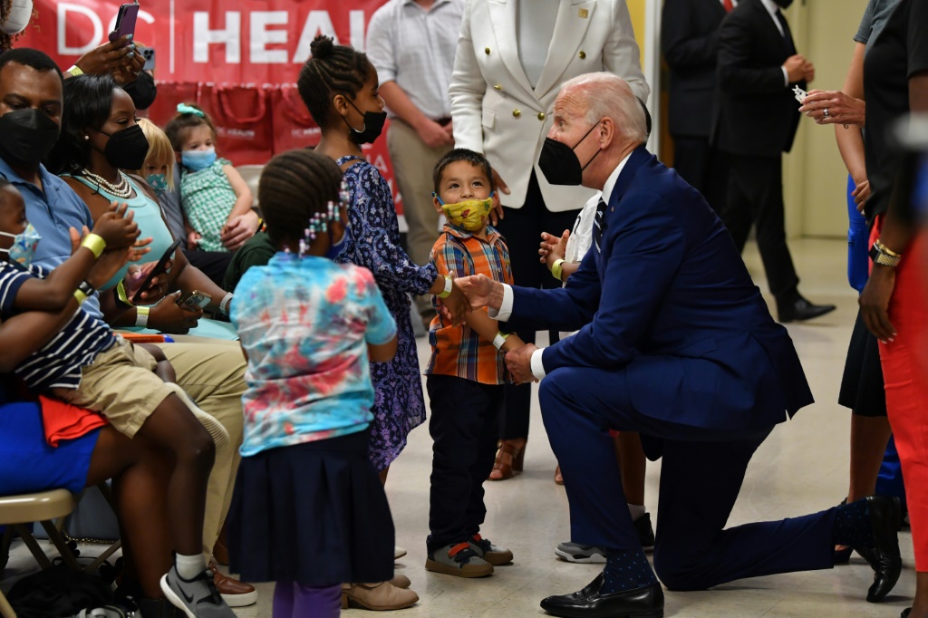    الرئيس الأمريكي جو بايدن يحيي الأطفال خلال زيارة لعيادة التطعيم ضد كوفيد -19 في واشنطن (أ ف ب)