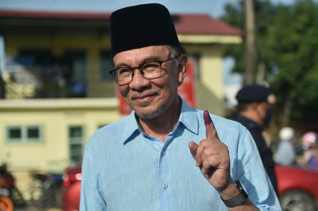 زعيم المعارضة الماليزية أنور ابراهيم يرفع سبابته وعليها آثار حبر بعد الإدلاء بصوته في الانتخابات التشريعية في ولاية بينانغ في 19 تشرين الثاني/نوفمبر 2022 (ا ف ب)
