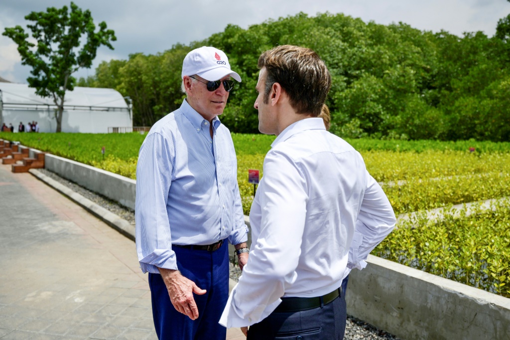 الرئيس جو بايدن (إلى اليسار) يتحدث مع الرئيس الفرنسي إيمانويل ماكرون خلال زيارتهما لغابة المانغروف على هامش قمة مجموعة العشرين في نوسا دوا، في منتجع جزيرة بالي الإندونيسية في 16 تشرين الثاني/نوفمبر 2022 (ا ف ب)