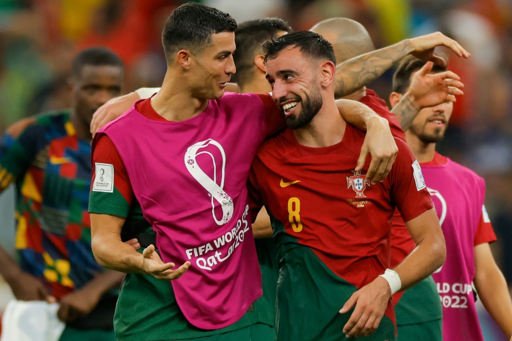 البرتغاليان كريستيانو رونالدو (يسار) وبرونو فرنانديش يحتفلان بعد التأهل إلى الدور الثاني من مونديال قطر، إثر الفوز على الأوروغواي بثنائية نظيفة، في 28 تشرين الثاني/نوفمبر 2022 (ا ف ب)