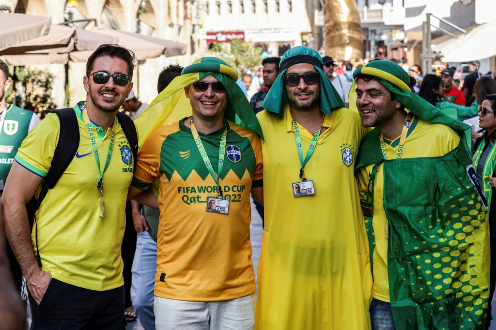 مشجعون برازيليون يرتدون أزياء عربية أثناء توقفهم لالتقاط صورة في سوق واقف في الدوحة في 28 تشرين الثاني/نوفمبر 2022 (أ ف ب)