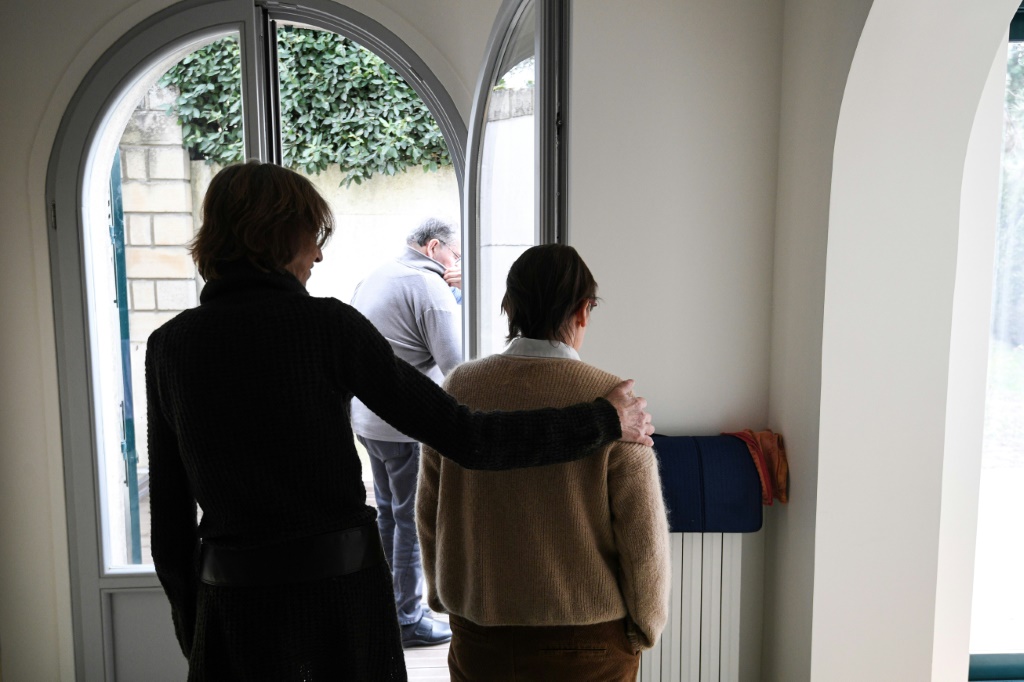 مساعدة ممرضة تساعد إحدى المريضات بالألزهايمر داخل مركز متخصص في أي-لي روز بضواحي باريس في 17 شباط/فبراير 2022 (ا ف ب)