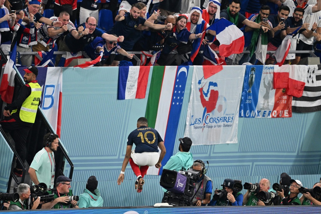 نجم فرنسا كيليان مبابي (رقم 10) يحتفل بتسجيله هدف الفوز لبلاده ضد الدنمارك في مونديال قطر ويبدو العلم الاوزبكي في الصورة. الدوحة في 26 تشرين الثاني/نوفمبر 2022 (ا ف ب)