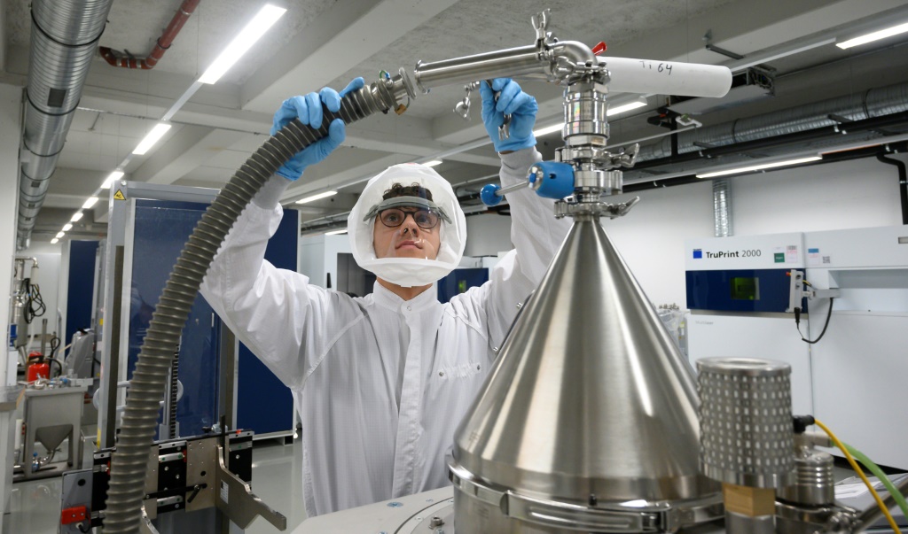 مهندس من شركة ترامبف الألمانية للتكنولوجيا الفائقة يقوم بإعداد معدات لإزالة الغبار لتنظيف وحدة منتجة في طابعة ليزر ثلاثية الأبعاد في معمل تطبيقات الشركة في ديتزينجين، جنوب ألمانيا في 30 تشرين الثاني/نوفمبر 2022 (ا ف ب)