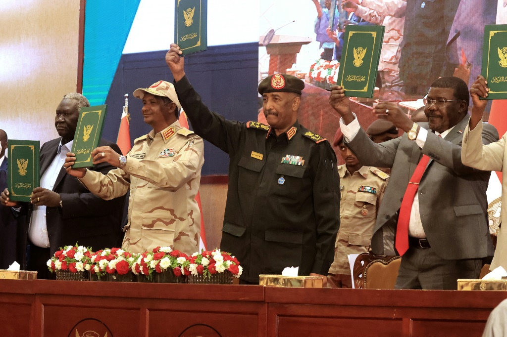    قائد الجيش السوداني عبد الفتاح البرهان وقائد القوات شبه العسكرية محمد حمدان دقلو إلى جانب القادة المدنيين بعد توقيع اتفاق أولي يهدف إلى إنهاء أزمة سياسية عميقة. (أ ف ب)