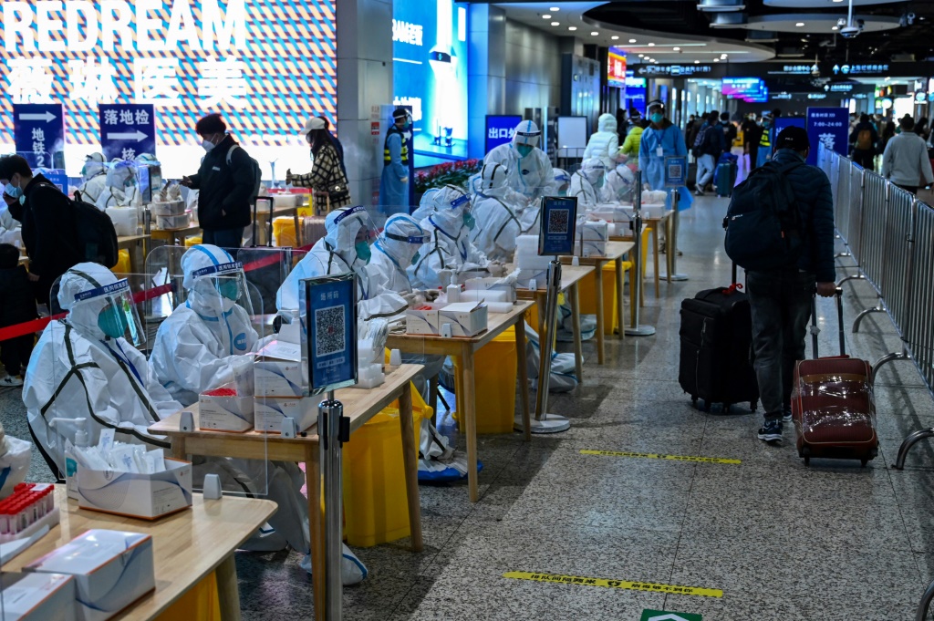 فرق الصحة تنتظر إجراء اختبارات كوفيد لمسافرين في محطة قطارات في شنغهاي، في 6 كانون الأول/ديسمبر 2022 (ا ف ب)