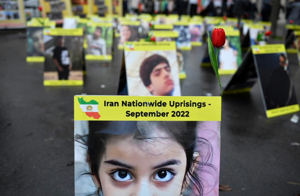 صورة التقطت قرب الجمعية الوطنية الفرنسية في باريس في 6 كانون الأول/ديسمبر تظهر لافتات عليها صور ضحايا حملة القمع في إيران (أ ف ب)
