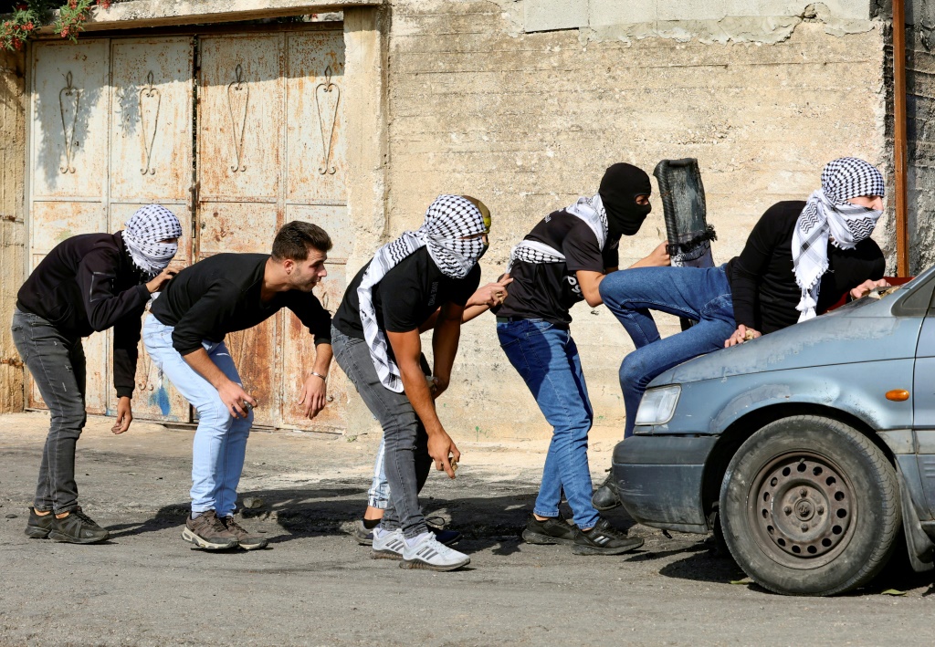 &nbsp;  متظاهرون فلسطينيون يحتمون خلال مواجهات مع جنود إسرائيليين بعد احتجاج على مصادرة إسرائيل لأراض فلسطينية في قرية كفر قدوم بالضفة الغربية المحتلة بالقرب من مستوطنة كدوميم اليهودية (ا ف ب)