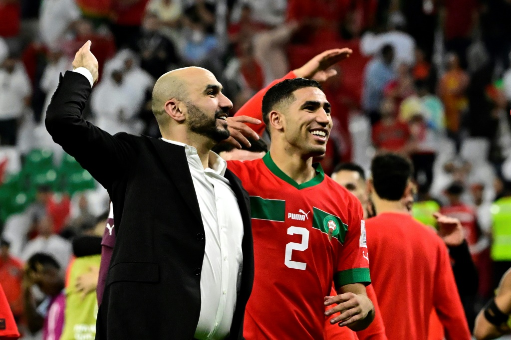    المدرب وليد الركراكي واللاعب أشرف حكيمي يحتفلان بفوز المغرب على إسبانيا في ثمن نهائي مونديال قطر، في 10 كانون الأول/ديسمبر 2022 (ا ف ب)